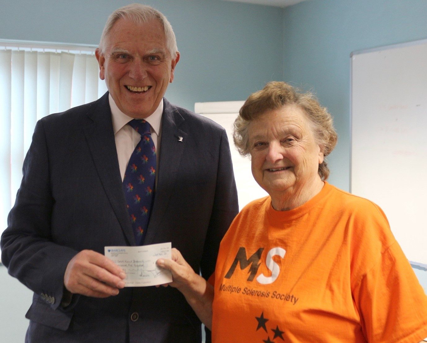 A picture of Peter West presenting the cheque to Dot Fisk the Group Coordinator.
