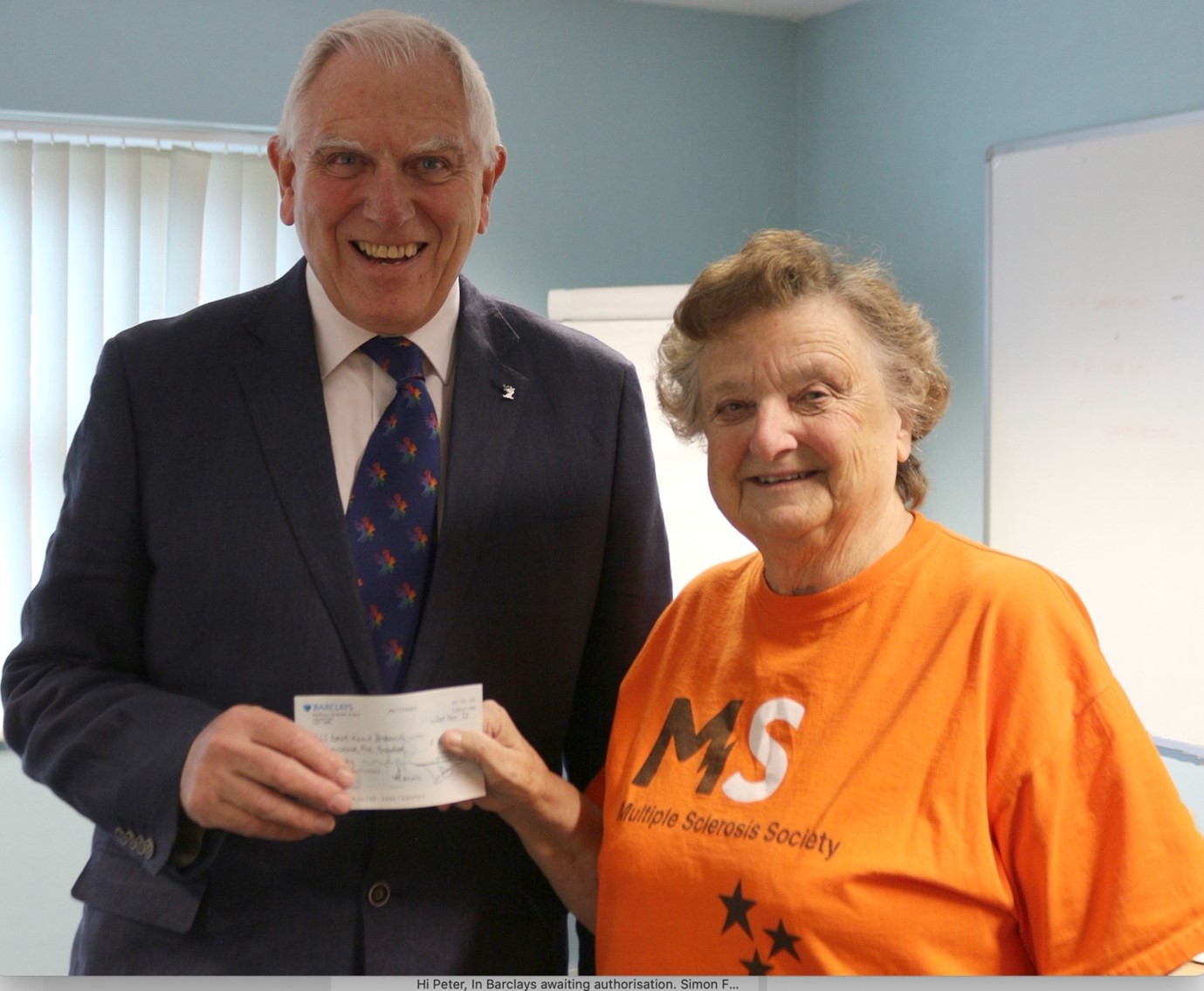 A picture of Peter West presenting the cheque to Dot Fisk the Group Coordinator.